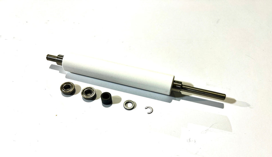 A white ZEBRA platen roller with metal shaft and several small black components placed around it, likely for installation or replacement in a thermal printer.